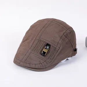 Close-up view of the vintage brown flat cap showcasing the front buckle and fabric texture.