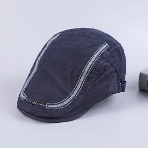 Detailed view of dark blue cotton flat cap for men, featuring stylish white stitching.