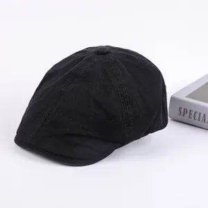 Close-up detail of the classic black cotton flat cap, showcasing fine stitching and texture.