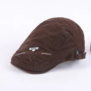 Detailed view of the brown men's cotton ivy cap with metal badge and casual design.