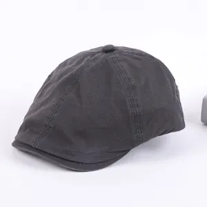 Detailed view of the dark grey cotton flat cap, showing fine stitching and classic newsboy design.