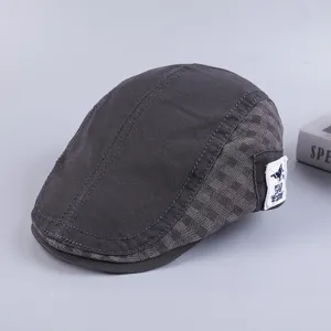 Detailed view of the dark grey cotton flat cap with side label, retro ivy newsboy hat style.