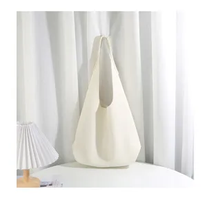 Detail view of a minimalist soft leather shoulder tote bag in white, simple lazy style.