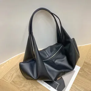 Nahaufnahme einer schwarzen minimalistischen slouchy Schulter-Tote-Bag auf Holzboden.