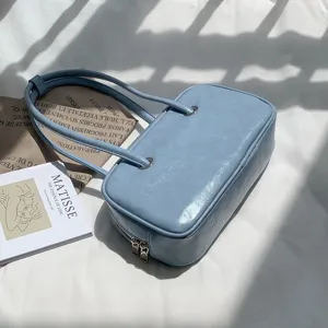 Light blue glossy oil-wax texture underarm shoulder bag with double straps and zipper closure.