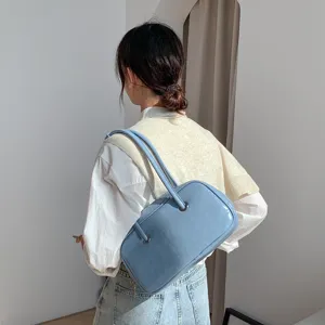 Back view detail shot of the stylish light blue oil-wax texture underarm bag with double handles.
