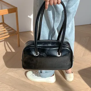 Black vintage patent leather shoulder bag for women, retro chic Boston handbag.