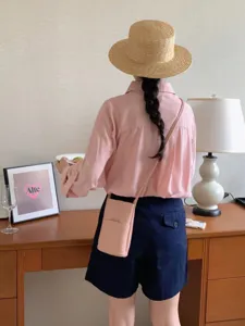 Minimalist pink crossbody phone bag with front card pocket for daily commute use.