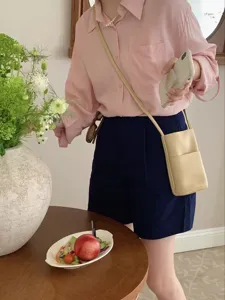 Minimalist commuter crossbody phone bag in beige leather, perfect for daily casual wear.