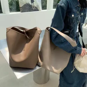 Detail view of stylish PU leather bucket bag in neutral tone, showing large capacity and strap.