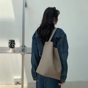 Minimalist PU leather shoulder tote bag, large capacity solid color bucket bag for daily use.