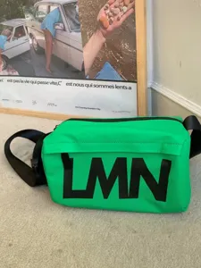 Green waterproof pillow crossbody bag with bold black letter print for casual sports use.