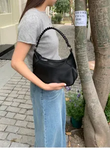 Detailed view of stylish black hobo shoulder bag featuring braided handle for daily wear.