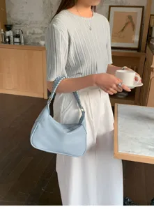 Detailed view of casual light blue shoulder bag with braided strap, daily lifestyle setting.