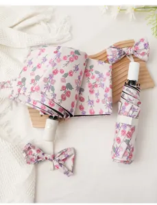 Compact floral folding umbrella with UV protection, black glue coating, and cute bow design.