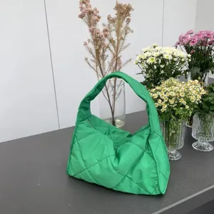 Green quilted shoulder bag detail showing soft fabric texture and neat diamond stitching pattern.