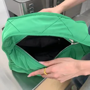 Green quilted nylon tote bag interior detail showing spacious compartment and secure zipper.