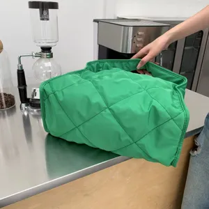 Detailed view of the bright green quilted puffer tote bag showing soft puffy texture.