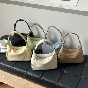 Minimalist woven handle shoulder handbag set displayed on a bench, chic daily PU leather tote.