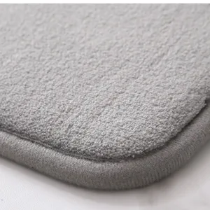 Close-up detail of soft gray memory foam bath mat, showing plush texture and neat bound edges.