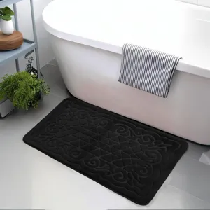Detail view of the black embossed flannel bath mat placed in a clean modern bathroom.