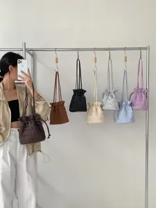 Detail view of pleated drawstring shoulder bag, stylish casual daily handbag for women.