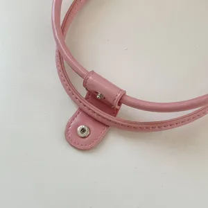 Pink PU leather handbag strap detail featuring secure metal snap button for stylish daily wear.