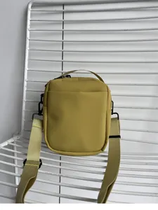 Minimalist mustard green small crossbody bag detail, lightweight mobile phone shoulder pouch.
