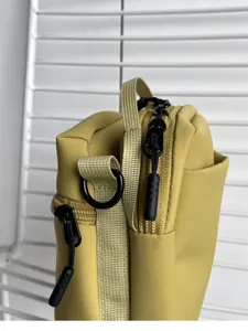 Detailed closeup view of yellow mini crossbody bag showing premium zipper and strap craftsmanship.