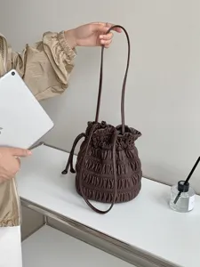 Close-up detail of the dark brown ruched drawstring bucket bag, soft leather and shoulder strap.