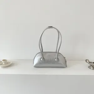Detailed shot of the minimalist silver underarm shoulder bag with long handle and sleek texture.