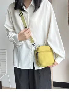 Compact yellow crossbody phone bag with zipper and handle for casual daily outdoor use.