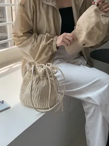 Detailed view of the chic beige ruched drawstring shoulder bag, showcasing soft texture.