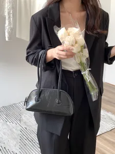 Black patent leather underarm shoulder bag, vintage shell shaped handbag with long handles.