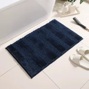 Tappetino da bagno in ciniglia blu scuro con dettagli della consistenza morbida e antiscivolo.