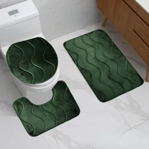 Vista dettagliata set tappeti bagno verde scuro ondulato con superficie strutturata antiscivolo.