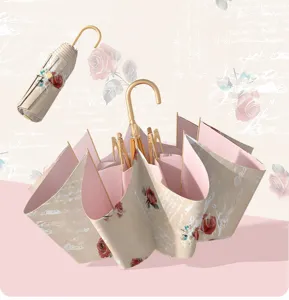 Paraguas plegable con estampado de rosas vintage, mango de gancho dorado y forro anti-UV.