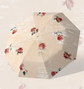 Paraguas plegable vintage con estampado de rosas y texto en ingles cursivo para proteccion solar.