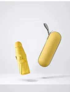 Detailed view of a compact yellow five fold sun umbrella with matching capsule case.
