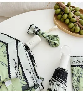 Detailed view of artistic oil painting style folding umbrella with green floral pattern UV protection