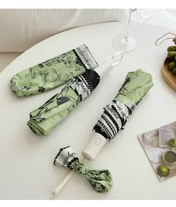 Compact folding sun umbrella with fresh green botanical print, uv protection, stylish and portable