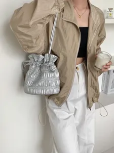 Detail view of a stylish silver metallic pleated drawstring shoulder bag, trendy and chic.