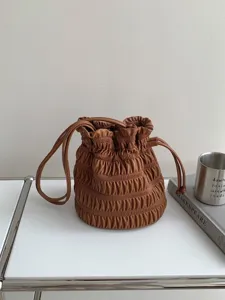 Brown ruched bucket bag for women, stylish leather-look shoulder handbag with drawstring.