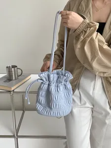 Details view of the light blue pleated drawstring bucket bag, elegant daily shoulder bag.