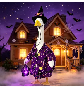 Detailed shot of Halloween porch goose outfit with witch hat and glowing lantern decoration.