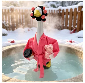 Detailopname van de grappige tuingans sculptuur met roze badjas in de sneeuw.