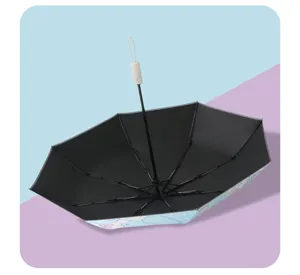 Detail view of children's folding automatic umbrella with black interior and cartoon print.