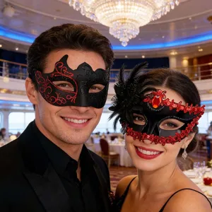 Detailansicht von Paaren Masken für Maskerade mit roten Mustern und eleganten schwarzen Federn.
