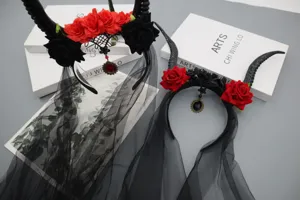 Cerchietto con corna da diavolo gotico, rose rosse e nere, velo a rete scuro e ciondolo gemma.