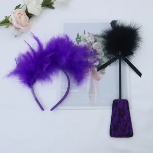 Set cerchietto con piume viola e frustino in piume nere, ideale per costume da festa e giochi.